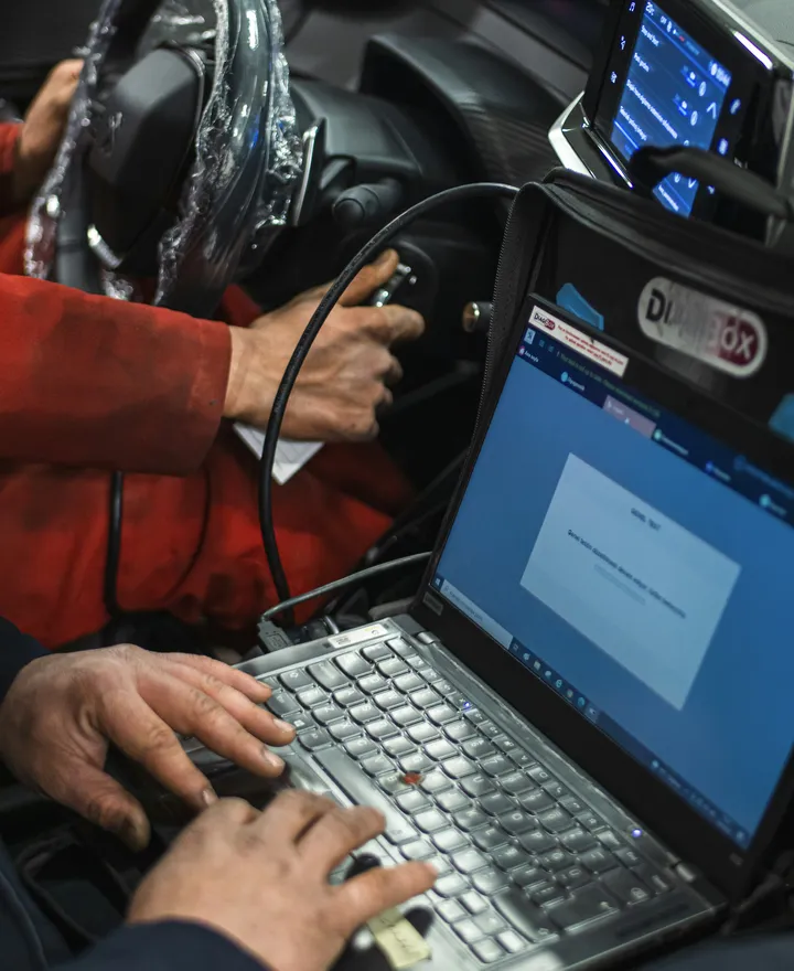 Técnico diagnosticando un vehículo con un computador portátil